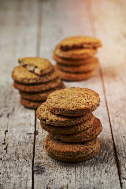 istock Three stacks of fresh baked oat cookies on rustic wooden table. 1456323547