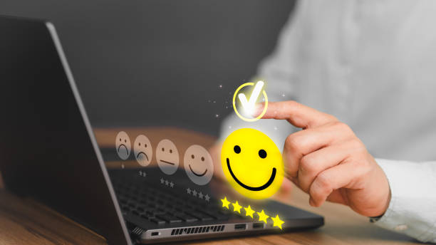 istock Male hand using a laptop computer with pop-up smile face five star icon for service reviews, satisfaction and testimonials. Customer Service Experience and Business Satisfaction Surveys. 1456329660
