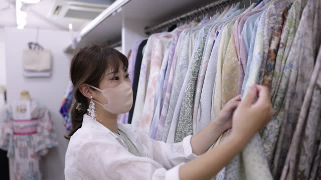 Woman choosing kimono in mental kimono shop
