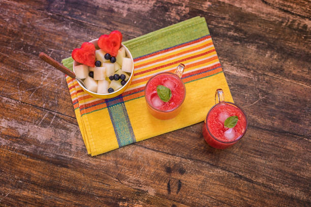 Fresh ripe watermelon piece at plate,  with glass of watermelon juice on table