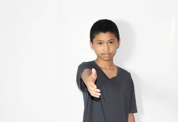 portrait of a teenage boy on white background with hands in pockets