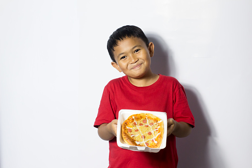 Asian boy eat pizza on white background