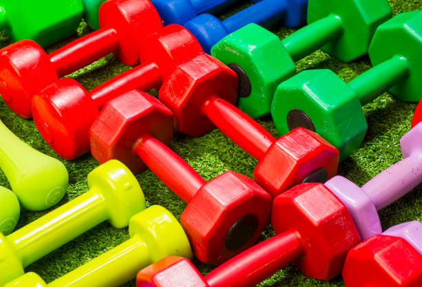 istock multi-colored dumbbells on a background of green grass 1456344053