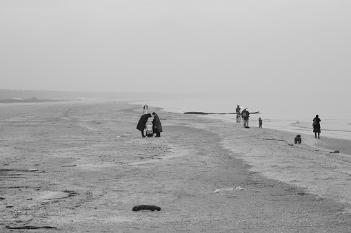 Black and white picture of families on the shore in a foggy day. The place is Porto Corsini, near Ravenna, Italy