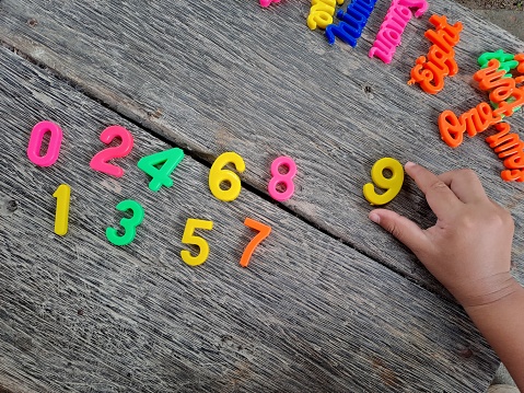 colorful numbers plastic toy on a wooden table. Concept of child learning numbers and child education