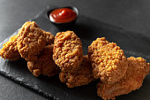 Fried chicken fillet on a dark background. Fried chicken wings as in KFC at home close-up.