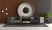 Living room with wooden wall paneling and two leather armchair