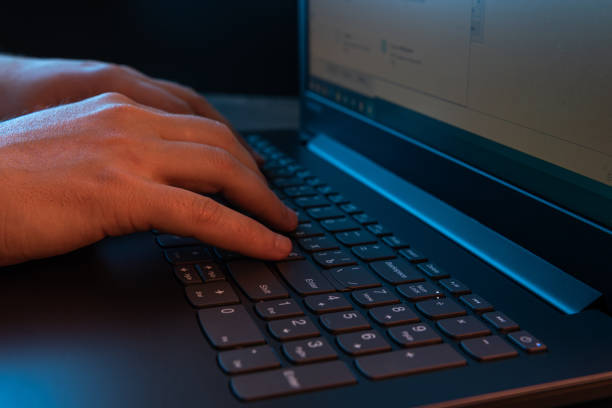 istock Hands of a man typing on a laptop keyboard. A man working on a laptop. Selective focus 1456350507