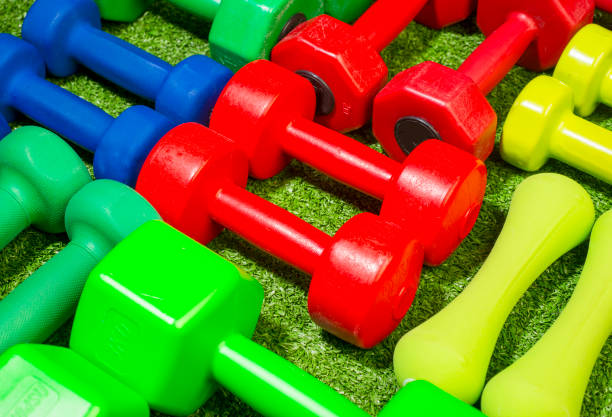 istock multi-colored dumbbells on a background of green grass 1456352271