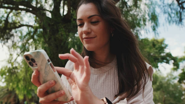 istock Close up, young woman using phone in the park 1456352347