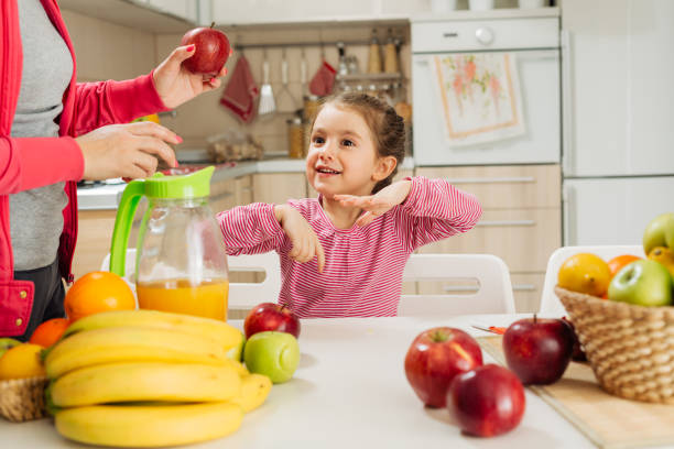 istock Girl playing with apple in the kitchen 1456352620