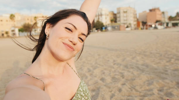 istock Happy young woman making funny faces and taking selfie 1456353724