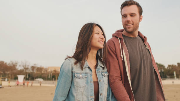 istock Couple in love hugging each other walking along the beach 1456353905