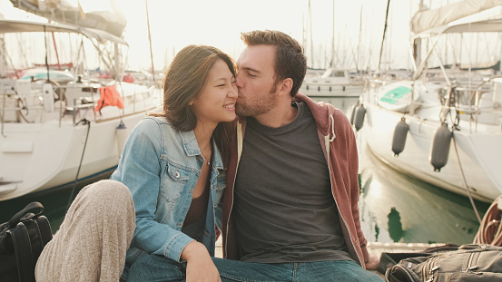 Loving couple kissing while sitting on the embankment