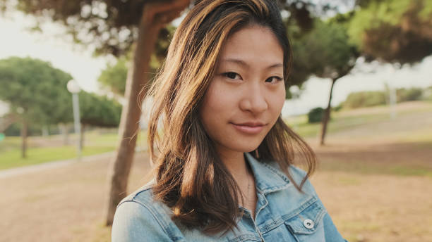 istock Close up, young woman posing at camera while standing in park. Looking at camera 1456354060