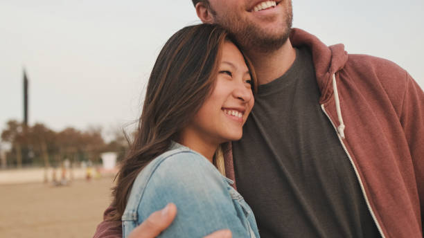 istock Couple in love spending time together standing on the beach 1456354062