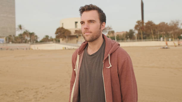 istock Young man enjoying walk on the beach 1456354145