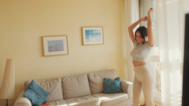 istock Young beautiful woman dancing at home, celebrating weekend, having fun. forward movement 1456355387