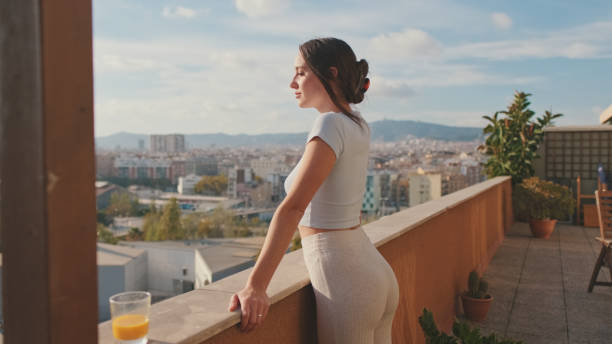istock Young woman enjoying beautiful view while standing on the balcony 1456355416