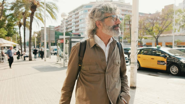 istock Middle-aged man walking down the street with backpack 1456355877