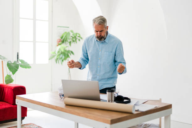 istock Shot of a senior businessman looking angry while using a laptop work 1456357146