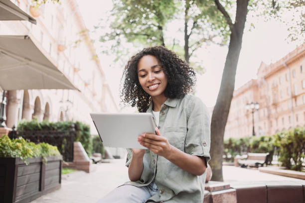 istock Happy woman using digital tablet in a city 1456360063