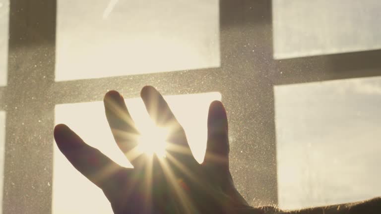 Human hand on background of sun. Backlight silhouette sunlight at sunset sunrise. The concept of love, dream, religion, faith in god, prayer, meditation. Christian Muslim raises his hands to the sky.