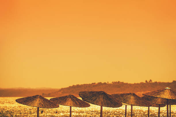 Seascape with straw sun umbrellas on the beach