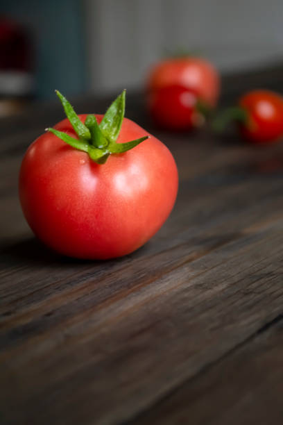 istock Red tomatoes on the table. Ripe tomatoes with a green tail on a wooden table. 1456363829