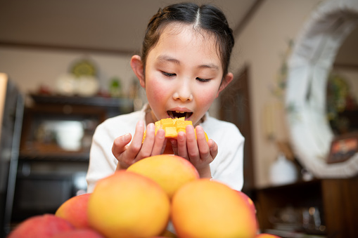 child eating ripe apple mango