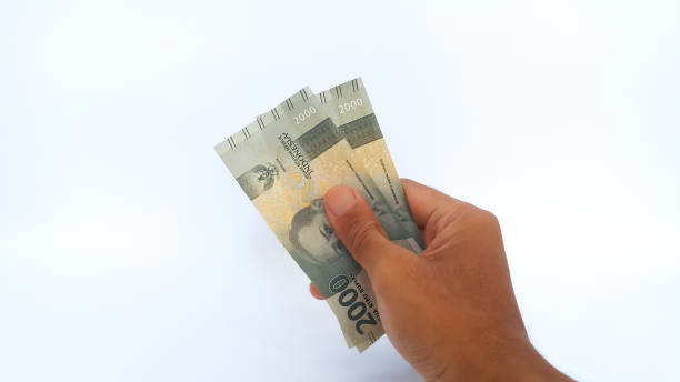 istock Hand holding Indonesian Rupiah money on white background 1456378716