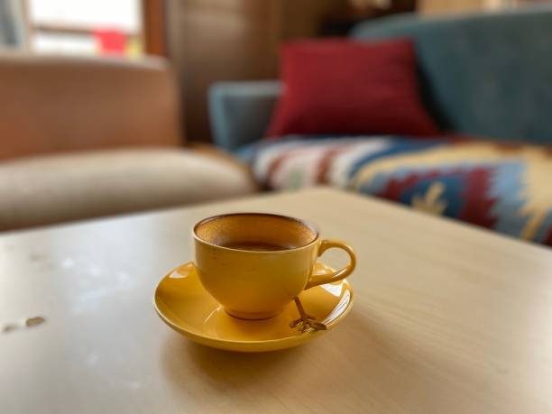 istock Coffee in yellow cup on wooden table in cafe 1456382454