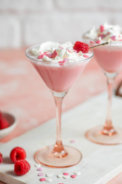 boisson au milkshake rose cocktail avec cœurs en sucre et crème fouettée pour la saint-valentin à la framboise - raspberry milkshake photos et images de collection