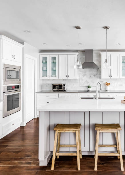 istock A white kitchen with wood stools sitting at the island. 1456385209