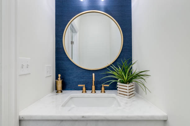istock A bathroom with blue wallpaper and gold sink and mirror. 1456386607