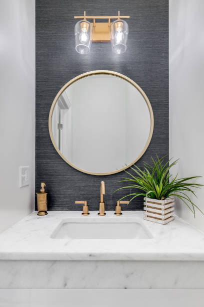 istock A bathroom with grey wallpaper and gold sink and mirror. 1456386610