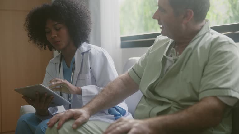 African american doctor discussing medical information with a mature male patient in a medical office.