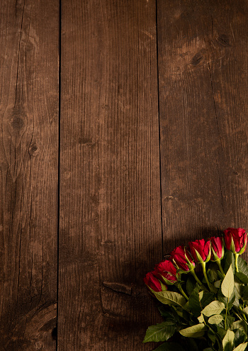 Rustic wood background with red roses for Valentine’s Day