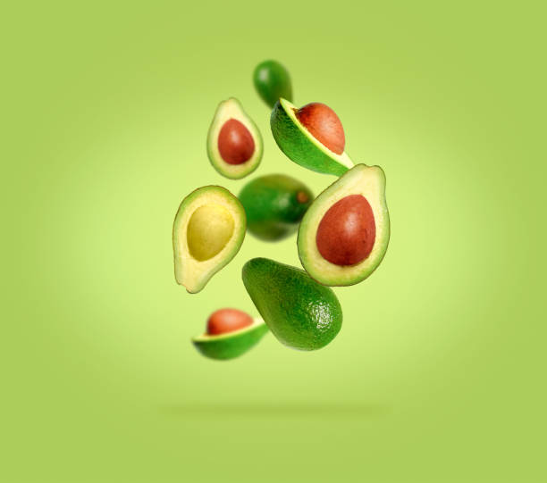 istock Sliced ​​and whole avocado in flight on gradient green background 1456393282