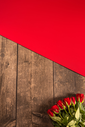 Rustic wood background with red roses for Valentine’s Day