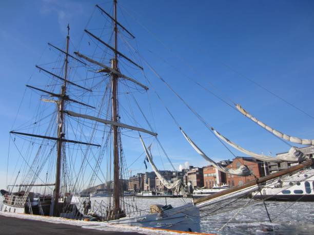 aker brygge in oslo with a sailing ship lying in the oslofjord  with ice floes, norway - dining nautical vessel recreational boat europe imagens e fotografias de stock