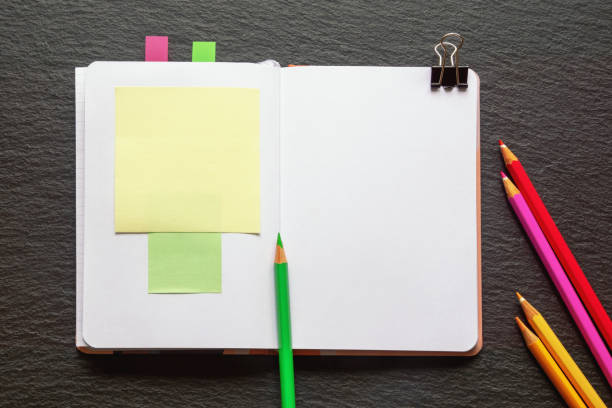 istock Open notepad and color pencils on the table. Flat lay, copy space 1456404758