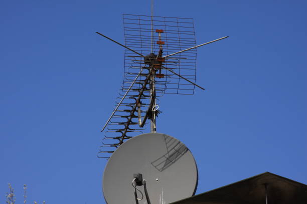 istock old antenna and a satellite dish on a house roof 1456404972
