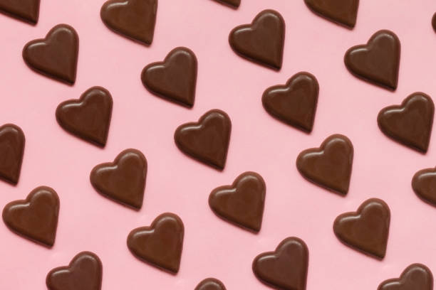 Pattern of chocolate bars shape heart, against pink background