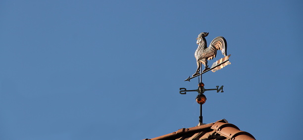 Madrid, Spain - September 25, 2022: Close-up of architectural detail on the upper part of a bank building. A bell tower with a golden ball is on top of the building.