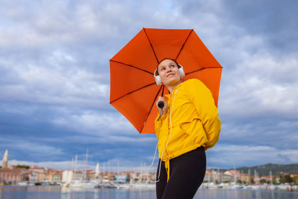 istock Standing by the sea with an orange umbrella 1456414672