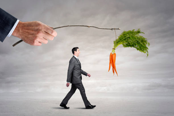 istock Businessman Follows Carrots Dangling From A Stick 1456419129
