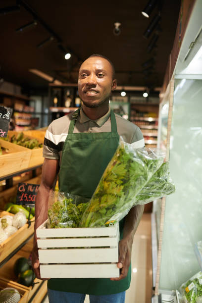istock Supermarket Worker with Box of Greens 1456419773
