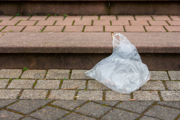a plastic garbage bag on a street stock photo
