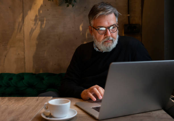 istock Mature businessman working on laptop at cafe 1456422089